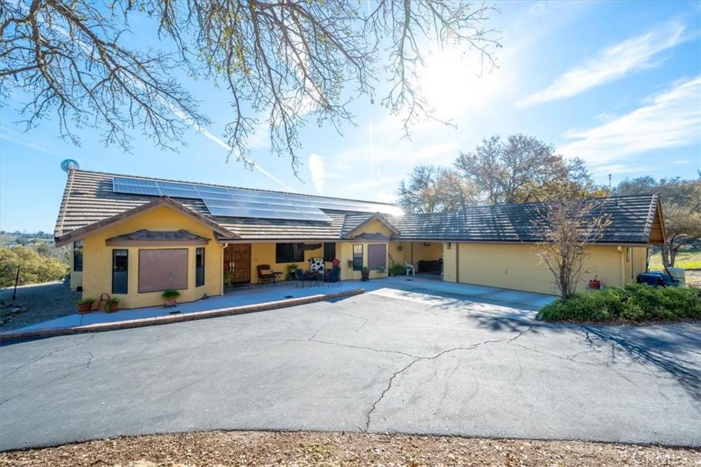 1885 Nacimiento Lake Dr, Paso Robles, CA 93446 - ranch-style house with driveway, roof mounted solar panels, stucco siding, a tiled roof, and a garage