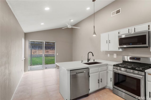 kitchen featuring pendant lighting, kitchen peninsula, sink, white cabinetry, and appliances with stainless steel finishes