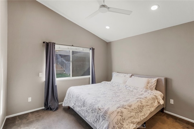 bedroom with ceiling fan, dark carpet, and vaulted ceiling