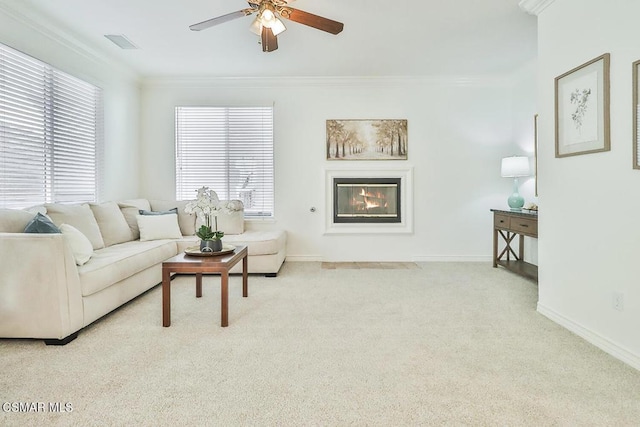 living room with ceiling fan, light colored carpet, and crown molding