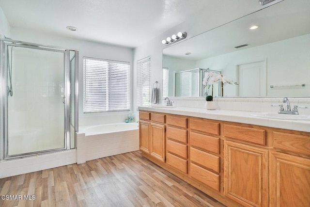 bathroom with shower with separate bathtub, hardwood / wood-style floors, and vanity