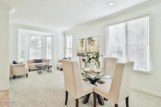 carpeted dining space with crown molding