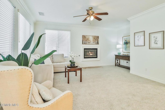 carpeted living room with ceiling fan and crown molding