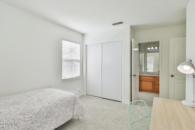 carpeted bedroom featuring a closet, sink, and connected bathroom