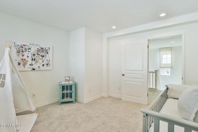 bedroom with light carpet and a crib