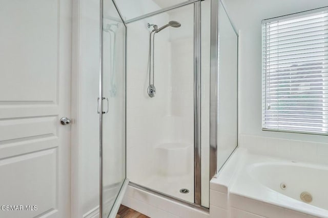 bathroom featuring independent shower and bath and a healthy amount of sunlight