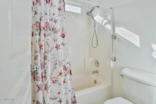 bathroom featuring toilet and shower / bath combination with curtain