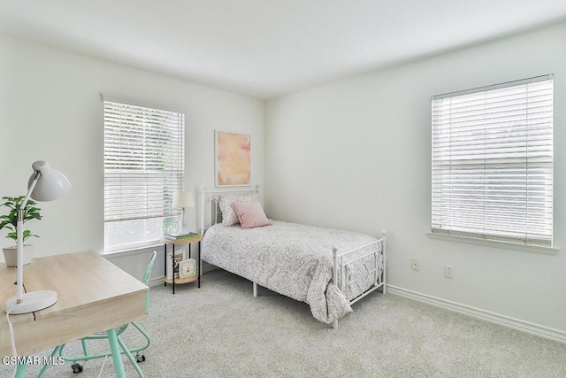 bedroom with light colored carpet and multiple windows