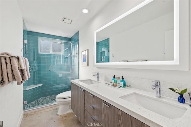 bathroom featuring toilet, a shower with door, and vanity