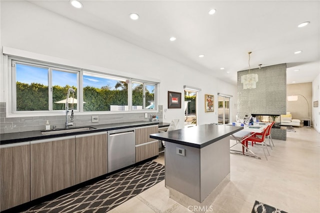 kitchen with dishwasher, a center island, decorative light fixtures, tasteful backsplash, and a multi sided fireplace