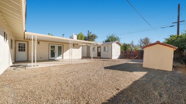 back of house featuring a storage shed, french doors, and a patio