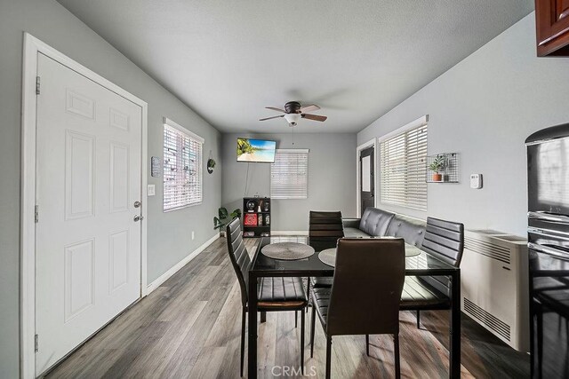 dining area with ceiling fan and hardwood / wood-style flooring