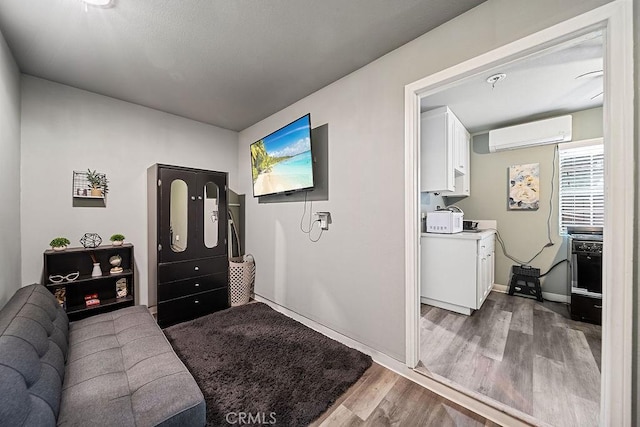 living room with hardwood / wood-style floors and an AC wall unit