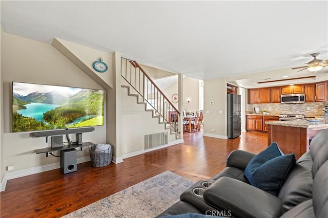 living room with ceiling fan and dark hardwood / wood-style flooring