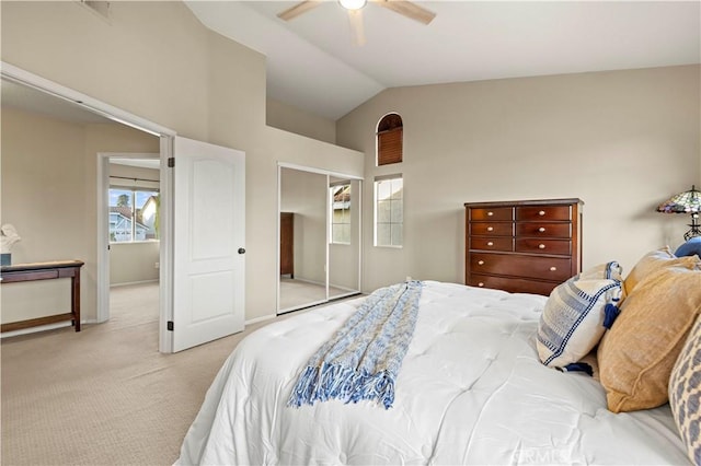 bedroom featuring vaulted ceiling, ceiling fan, a closet, and light colored carpet