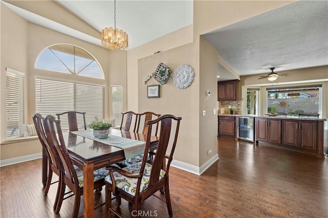 dining space featuring wine cooler, dark hardwood / wood-style floors, ceiling fan with notable chandelier, and lofted ceiling