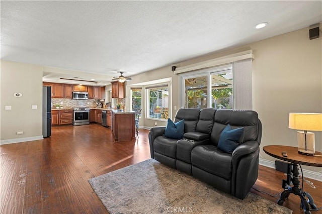 living room with ceiling fan and dark hardwood / wood-style flooring