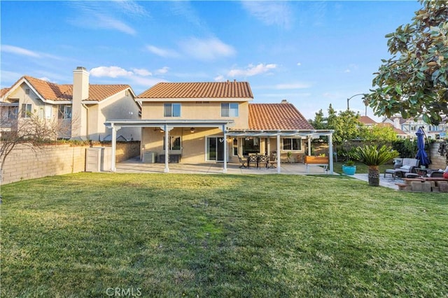 rear view of house with a patio area and a lawn