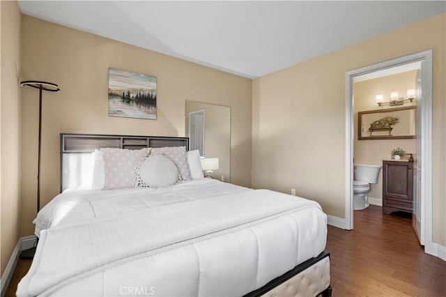 bedroom featuring ensuite bathroom and dark hardwood / wood-style floors