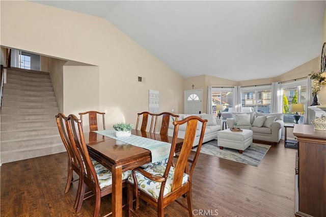 dining space with dark hardwood / wood-style floors and lofted ceiling