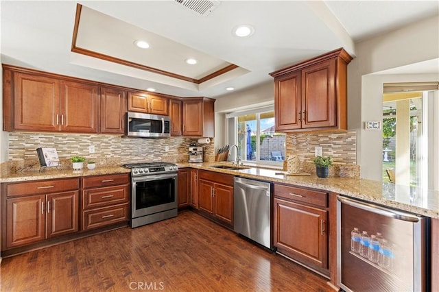 kitchen with beverage cooler, appliances with stainless steel finishes, decorative backsplash, dark hardwood / wood-style floors, and a raised ceiling