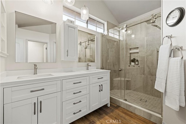 bathroom featuring hardwood / wood-style flooring, lofted ceiling, an enclosed shower, and vanity