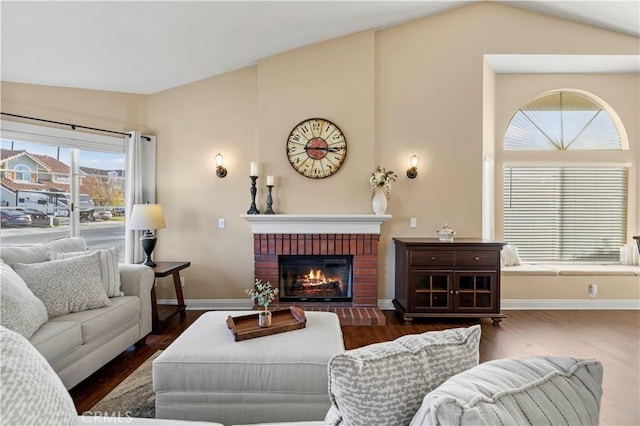 living room with a wealth of natural light, lofted ceiling, a fireplace, and dark hardwood / wood-style flooring