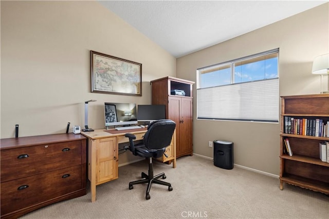 office space with light colored carpet and vaulted ceiling