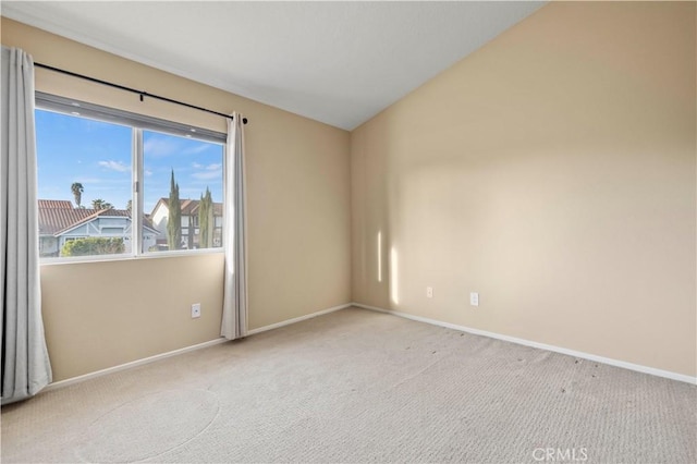 unfurnished room featuring light carpet and vaulted ceiling