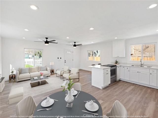 living room featuring sink, ceiling fan, and light hardwood / wood-style floors