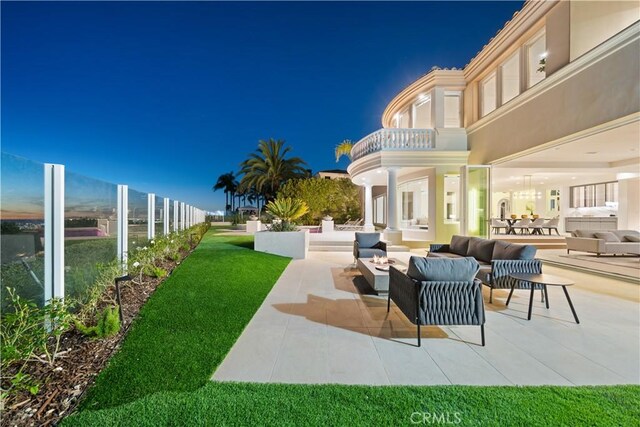 exterior space featuring an outdoor living space, a patio area, and a balcony