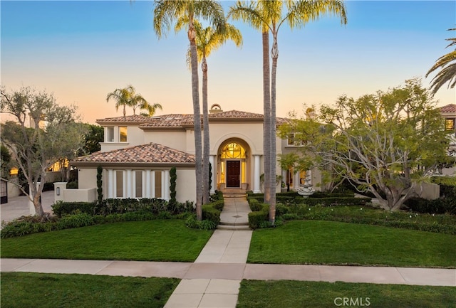 mediterranean / spanish-style home with a lawn