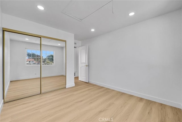 unfurnished bedroom with a closet and light hardwood / wood-style floors