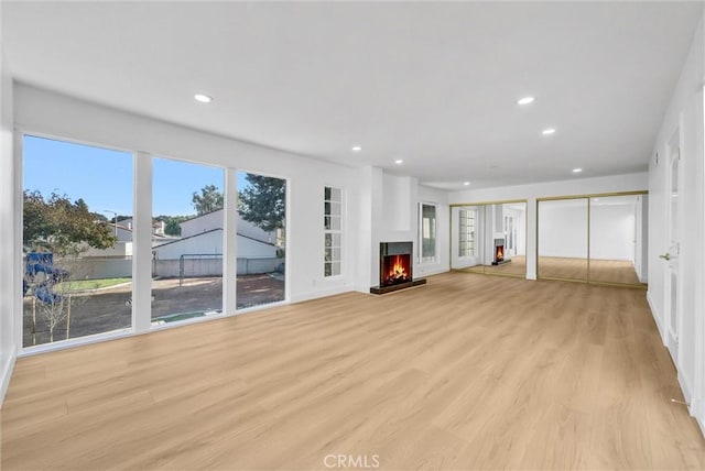 unfurnished living room featuring light wood-type flooring and plenty of natural light