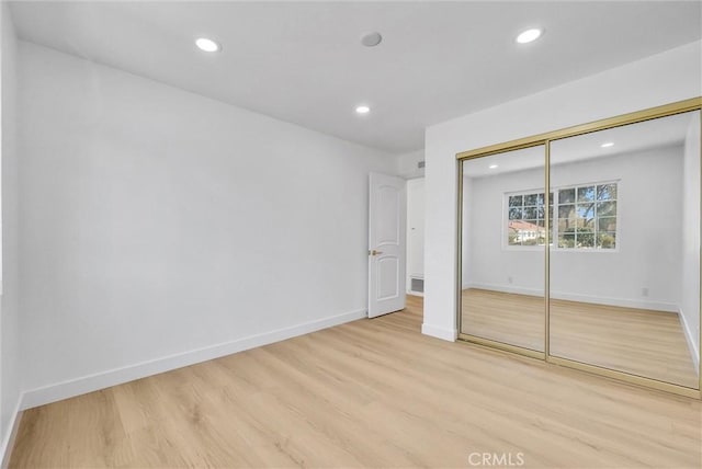 unfurnished bedroom featuring a closet and light hardwood / wood-style flooring