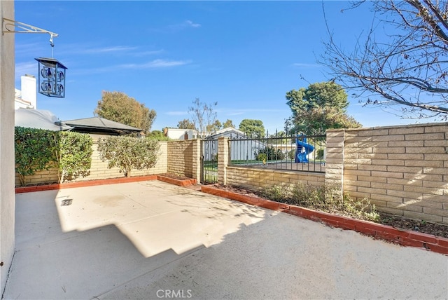 view of gate with a patio