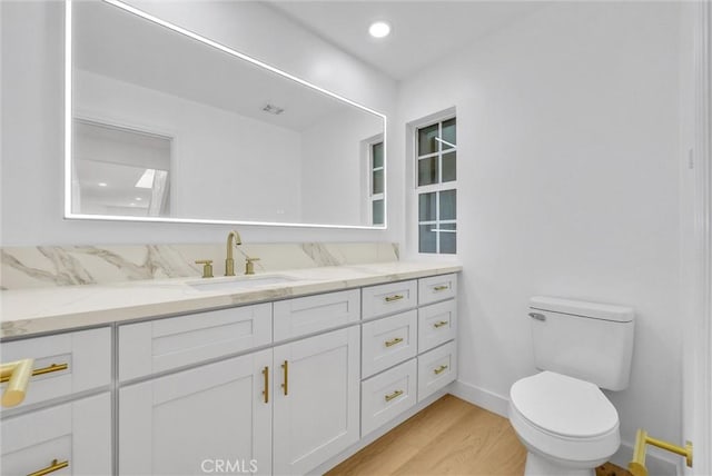 bathroom featuring hardwood / wood-style flooring, vanity, and toilet