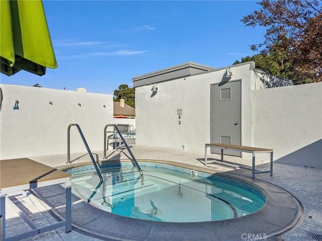 view of pool featuring a community hot tub and a patio