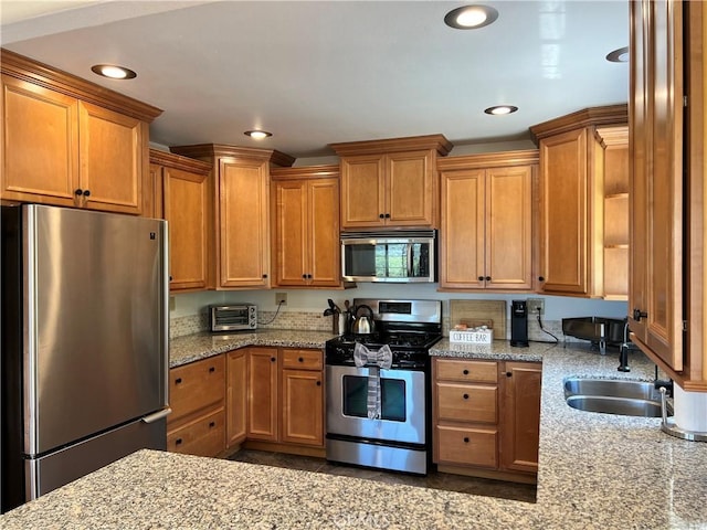 kitchen with sink, light stone counters, and stainless steel appliances