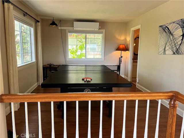 playroom featuring an AC wall unit and hardwood / wood-style flooring