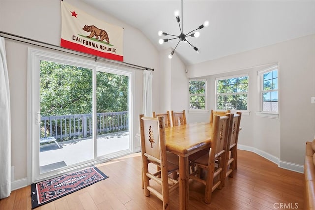 dining room featuring an inviting chandelier, lofted ceiling, and wood-type flooring