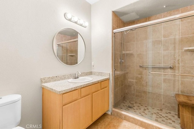 bathroom featuring an enclosed shower, vanity, toilet, and tile patterned flooring