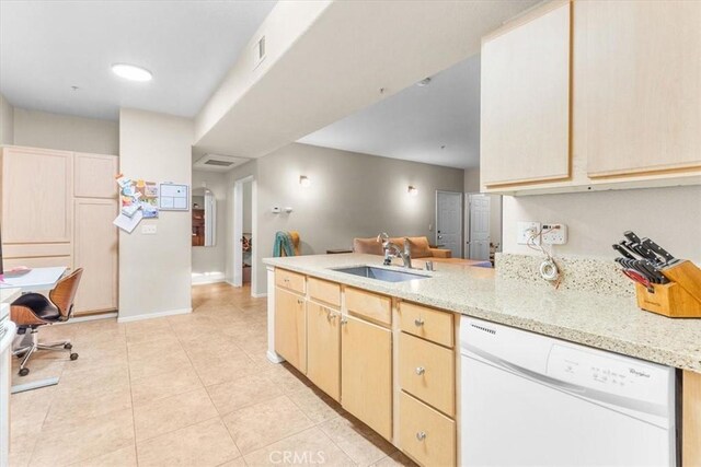 kitchen featuring kitchen peninsula, light brown cabinetry, white dishwasher, light stone counters, and sink