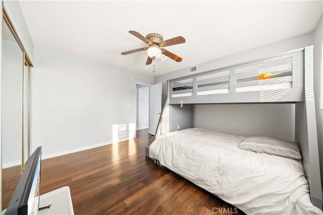 bedroom with ceiling fan, dark hardwood / wood-style floors, and a closet