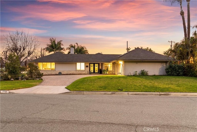 single story home with a lawn