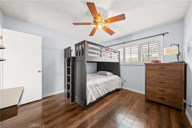 bedroom with ceiling fan, dark hardwood / wood-style floors, and a textured ceiling