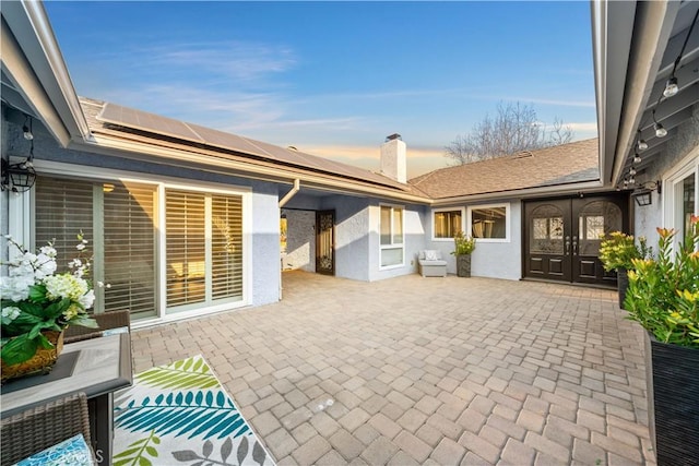 patio terrace at dusk featuring french doors