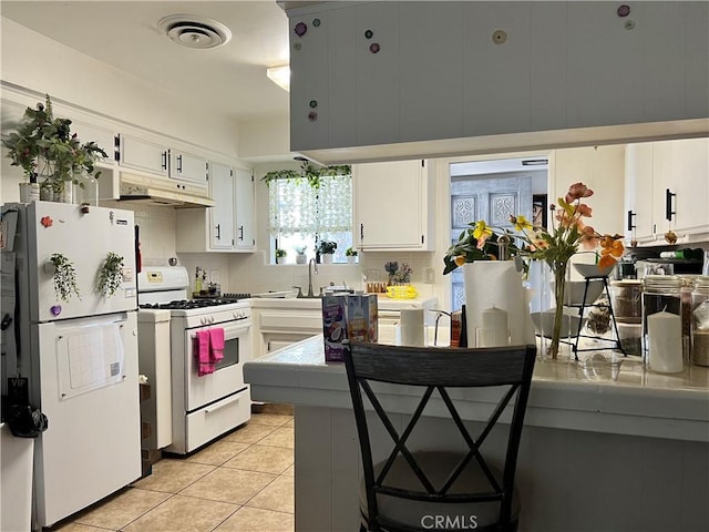 kitchen featuring white appliances, white cabinetry, sink, backsplash, and light tile patterned floors