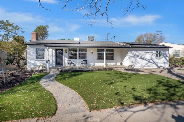 ranch-style house with a front lawn, a porch, and solar panels