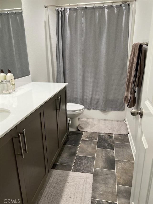 full bathroom featuring shower / bath combo with shower curtain, toilet, and vanity